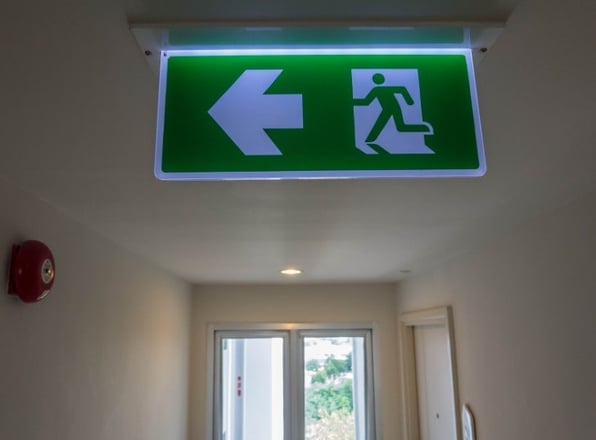 A emergency light, situated in a commercial property, that is tested frequently to meet emergency lighting requirements. 